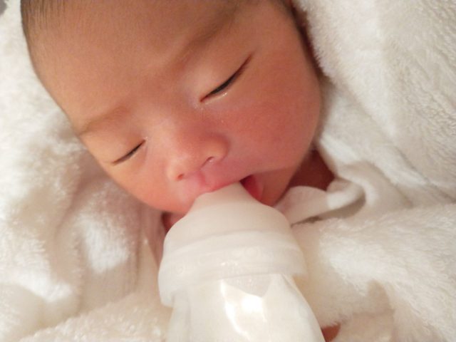 新生児の娘がミルクを飲んでいるのを撮影した写真